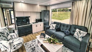 Un espacio habitable compacto con sofá, una mesita de centro y una kitchenette.