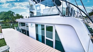 Un barco blanco con fachada de cristal, cubierta y un cartel que dice 'CAME CROSSING MARINA'.