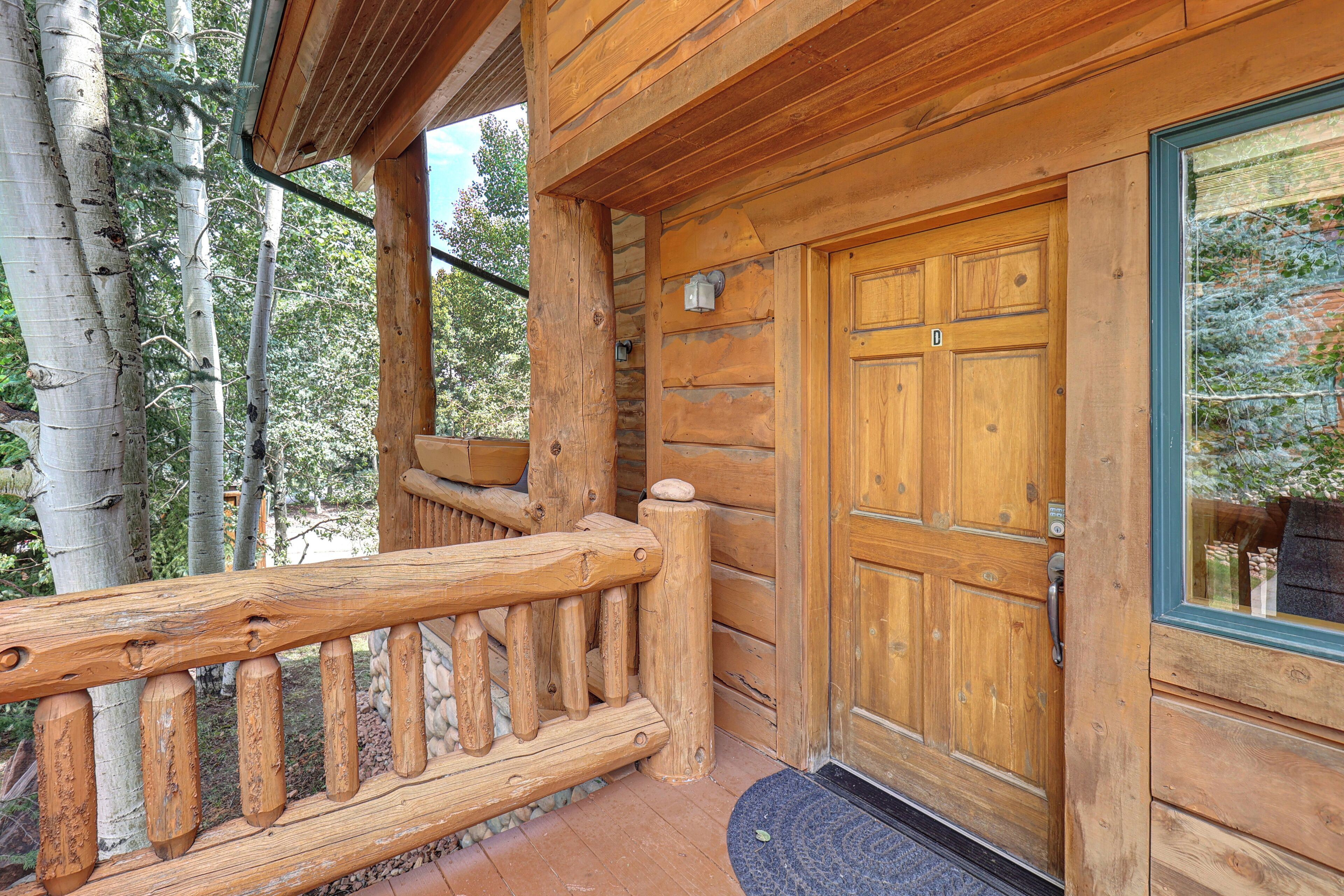 Une cabane en bois avec une porte en bois et une fenêtre en verre.