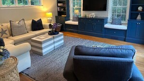 Un salon avec un canapé, une table basse et un téléviseur fixé au mur.