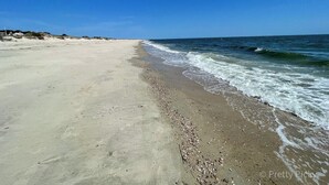 Une plage avec un ciel dégagé et une mer calme.