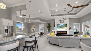 A modern kitchen with a large island, bar stools, and a built-in oven. - ⭐Luxury Home with Private Pool and Outdoor Kitchen-Memories on Madison⭐ (Fort Myers Beach)