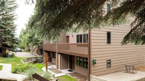 Un bâtiment moderne doté d’un toit plat, de grandes fenêtres et d’une terrasse en bois.
