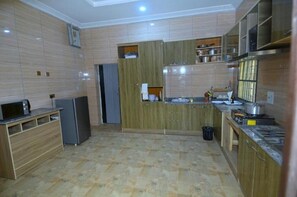 Une cuisine avec des meubles de rangement en bois, un réfrigérateur, un four à micro-ondes et un évier.