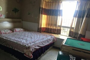 A bedroom with a bed, a window with curtains, and a pool table. - Jiangwen Apartment (Chongqing)