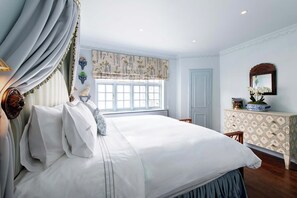 Relax in a spacious bedroom with a large bed, dresser, and mirror.