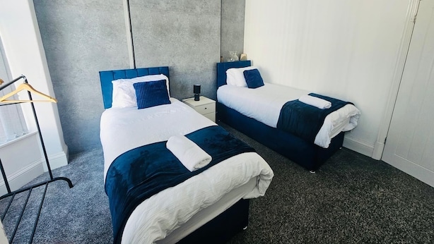 Een hotelkamer met twee bedden, een kledingkast en een nachtkastje.