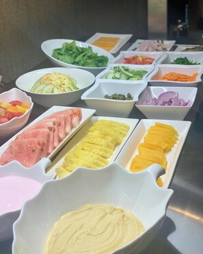 A buffet with various food items including meats, vegetables, and dips. - The Citron Hotels (Ibadan)