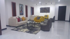 A modern living room with a sofa, armchairs, and a coffee table. - The Citron Hotels (Ibadan)