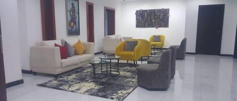 Una sala de estar moderna con un sofá, sillones y una mesa de centro.