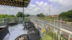 A rooftop terrace with outdoor seating, a view of the road, and surrounding greenery. - The Citron Hotels (Ibadan)