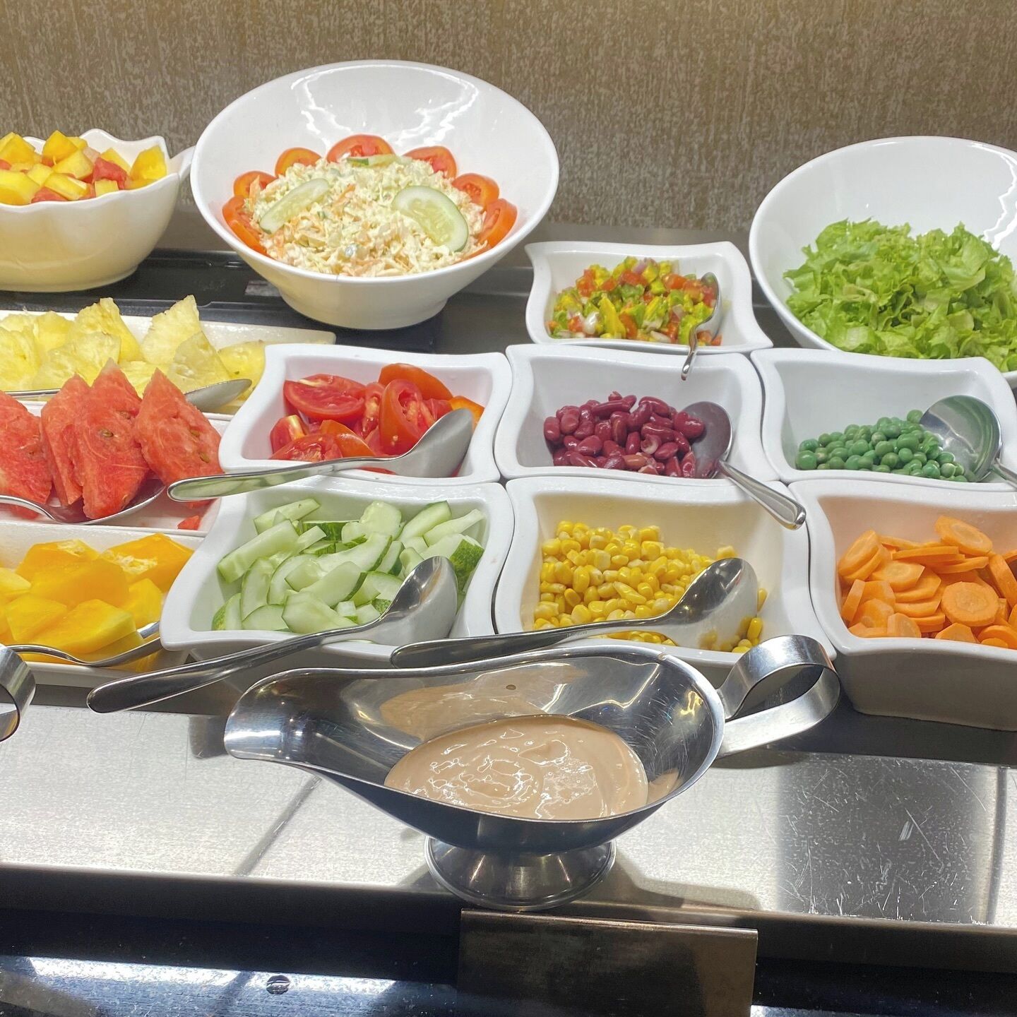 Ein Buffet mit verschiedenen Speisen, darunter Obst, Gemüse und Dips.