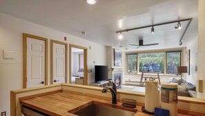 Una cocina moderna con encimera de madera, pileta de acero inoxidable y lavavajillas integrado.