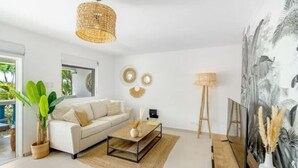 Un salon moderne avec un canapé, une table basse et un grand tableau accroché au mur.