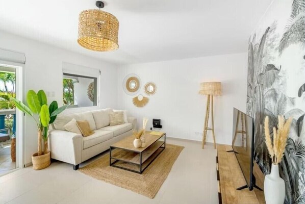 A modern living room with a sofa, coffee table, and a large painting on the wall.