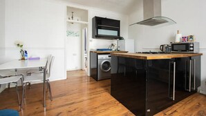 A compact kitchen with a microwave, kettle, and a small sink. - Charming London Apartment Near Hyde Park (London)
