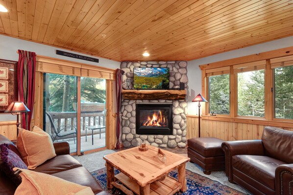 A cozy living room with a stone fireplace, leather sofas, and a large TV screen. - Timber Wolf Lodge 10d 2 Bedroom Condo by RedAwning (Park City)