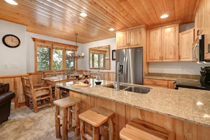 A kitchen with wooden cabinets, granite countertops, and a stainless steel refrigerator. - Timber Wolf Lodge 10d 2 Bedroom Condo by RedAwning (Park City)