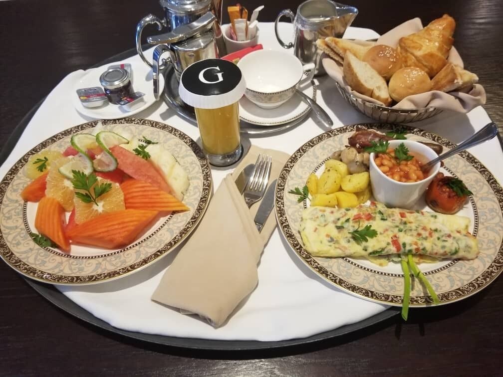 A breakfast tray with salmon, eggs, and bread on a table.