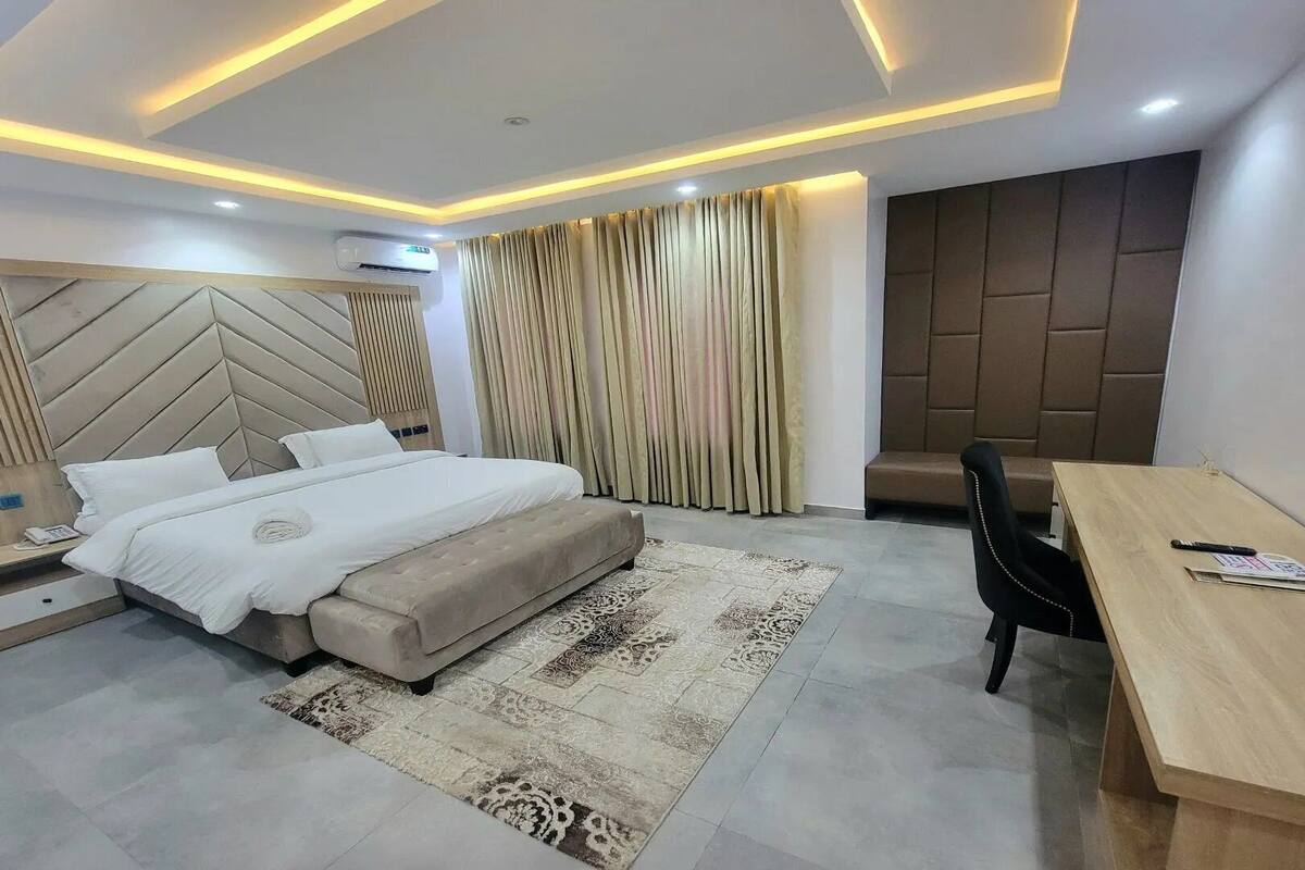 Une chambre à coucher moderne avec un grand lit, un bureau et une chaise.