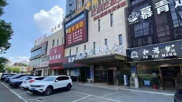 A multi-story building with various commercial establishments on the ground floor, including a hotel with a visible sign.