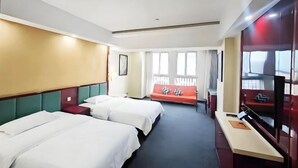 A hotel room with two beds, a sofa, a TV, and a window with curtains. - Memory Hotel (Zhenjiang)