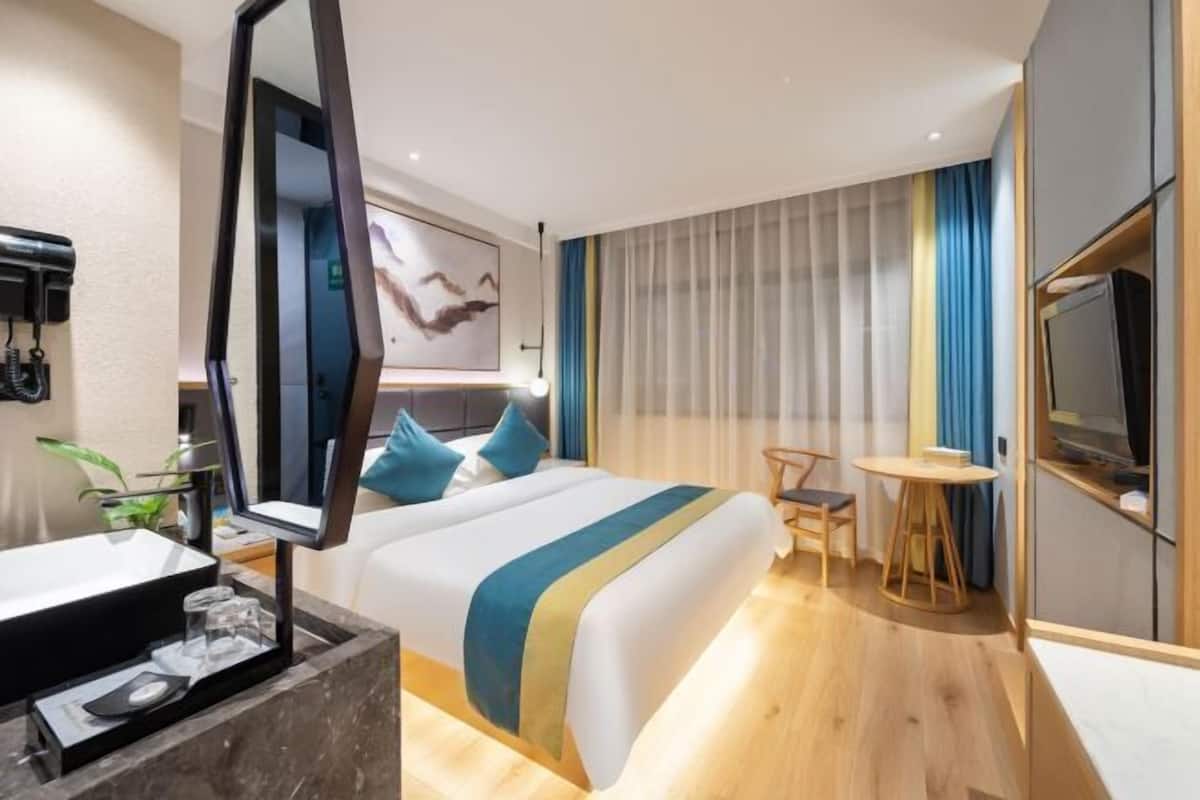 Et moderne hotelværelse med en stor seng, et sengebord og et fjernsyn.