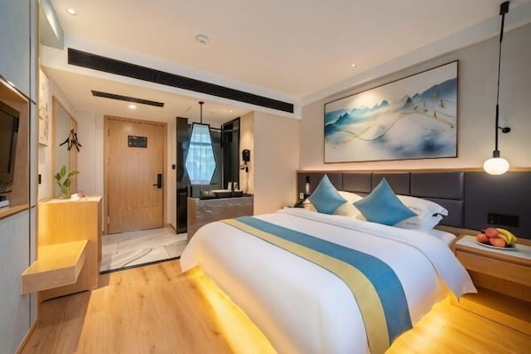 A modern hotel room with a large bed, bedside tables, a TV, a painting, and a view of the outdoors. - Outing Boutique Hotel Yiwu International Trade City (Yiwu)
