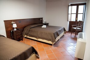 A hotel room with a bed, bedside table, lamp, chair, and a window. - Dimora del Borgo Affittacamere (Sangineto)