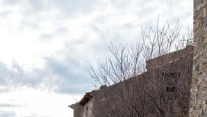 Un edificio de piedra con techo de tejas, un cartel que dice "DIMORA DEL BORGO" y una escalera que conduce a una puerta.
