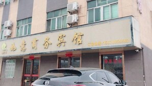 Rakennuksessa on kyltti, jossa lukee ”小柴小商务酒店”, ja siinä on myös puhelinnumero.
