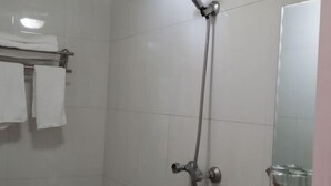 Ein Badezimmer mit Dusche, Handtuchhalter mit Handtüchern und einem Spiegel.