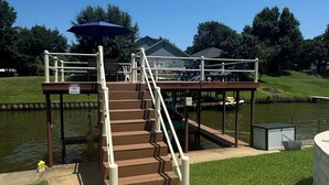 A wooden staircase leading to a dock over a body of water, with a 'Danger' sign visible.