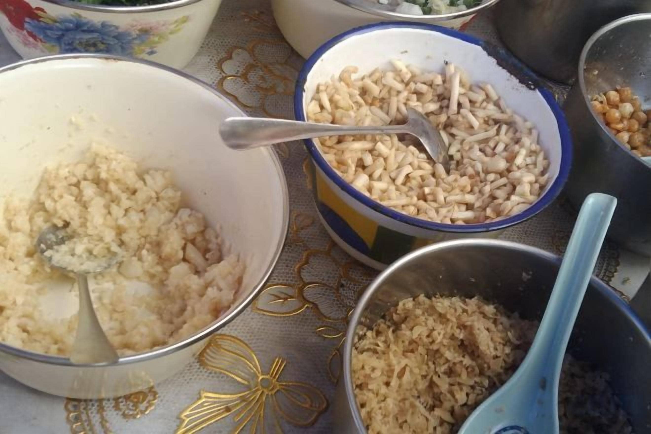 A table with various food items in bowls, including rice and other grains.