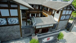 A traditional Japanese-style building with multiple levels, wooden balconies, and tiled roofs. - Yiyi Hotel (Dujiangyan)