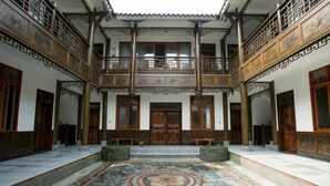 A traditional building with a central courtyard, wooden balconies, and a patterned floor. - Yiyi Hotel (Dujiangyan)