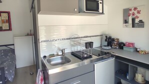 Una cocina funcional con microondas, fregadero y electrodomésticos modernos.