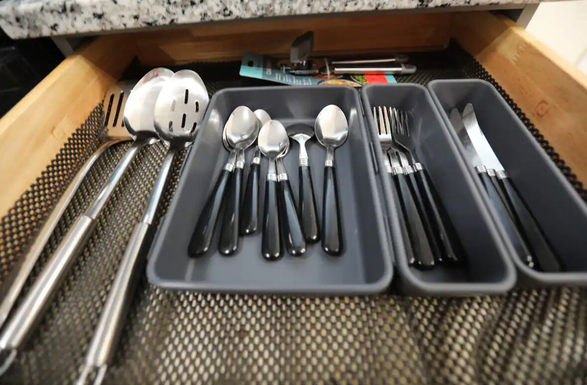 A drawer with utensils and cutlery organized in compartments.