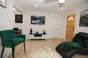 Relax in this stylish living room with a flat-screen TV, comfortable sofa, and plush chair.