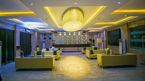 A lobby with a chandelier, yellow sofas, and a reception desk. - Echelon Heights Hotel (Port Harcourt)