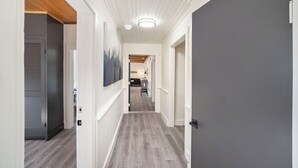 A hallway with wooden flooring, white walls, and a ceiling with wooden beams. - Spacious downtown apartment with parking (Douglas)