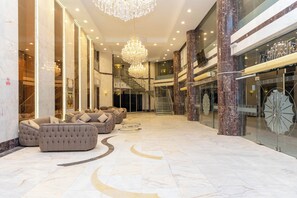 A spacious lobby with a grand chandelier, plush seating, marble flooring, and a staircase leading to upper levels. - Mahd Al Resala 1 Hotel (Makkah)