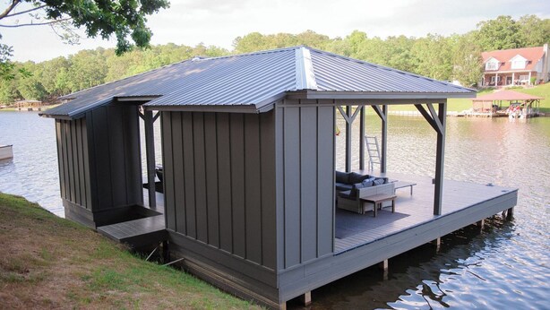 Un abri pour bateaux aménagé avec un espace de repos couvert et une petite terrasse.
