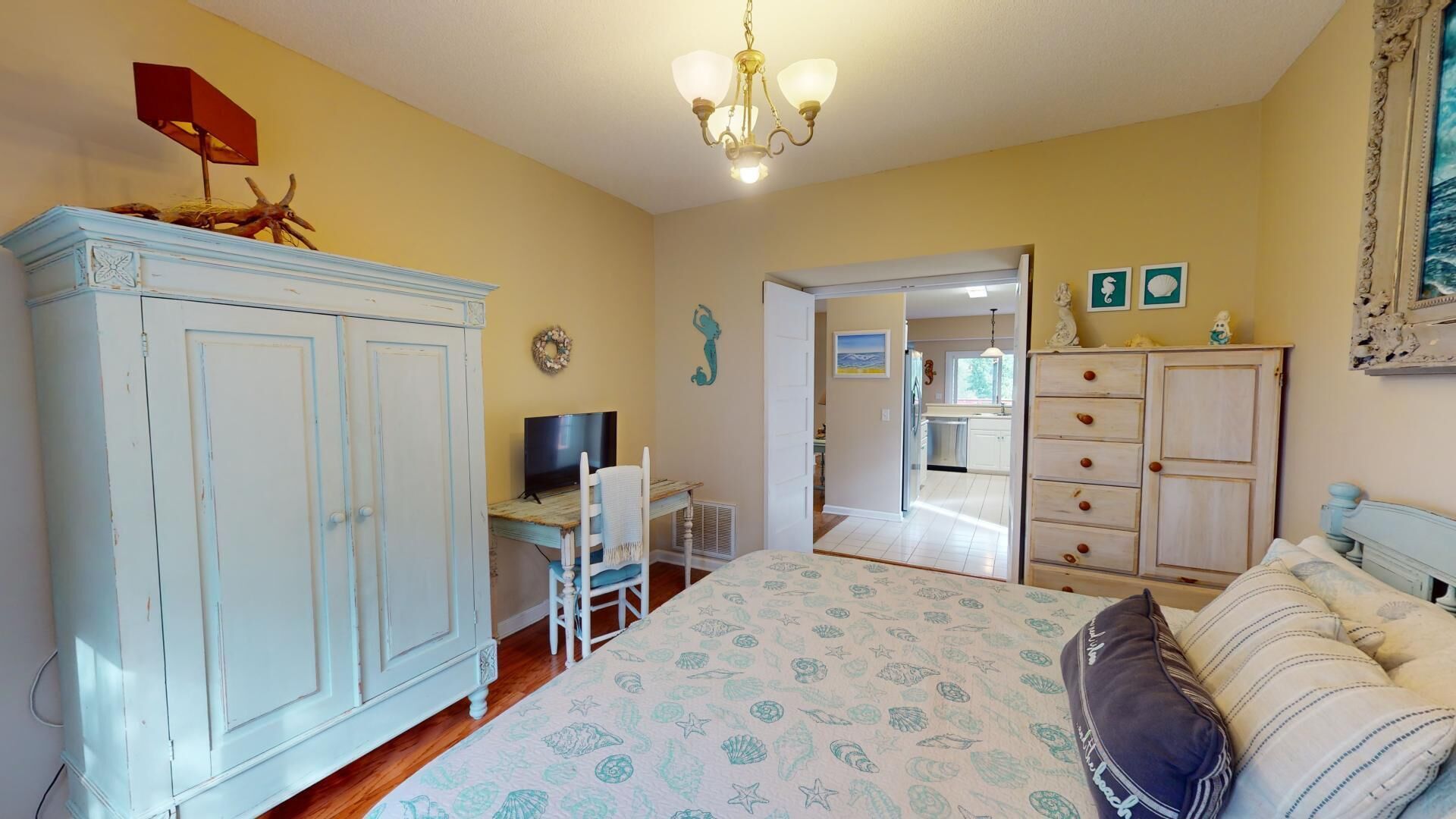 Une chambre à coucher avec un lit, un bureau, une armoire et un téléviseur.