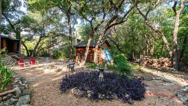 A rustic cabin surrounded by trees, a small garden with a stone path, and outdoor seating. - Zilker Park, Town lake, and Barton Springs pool (Austin)