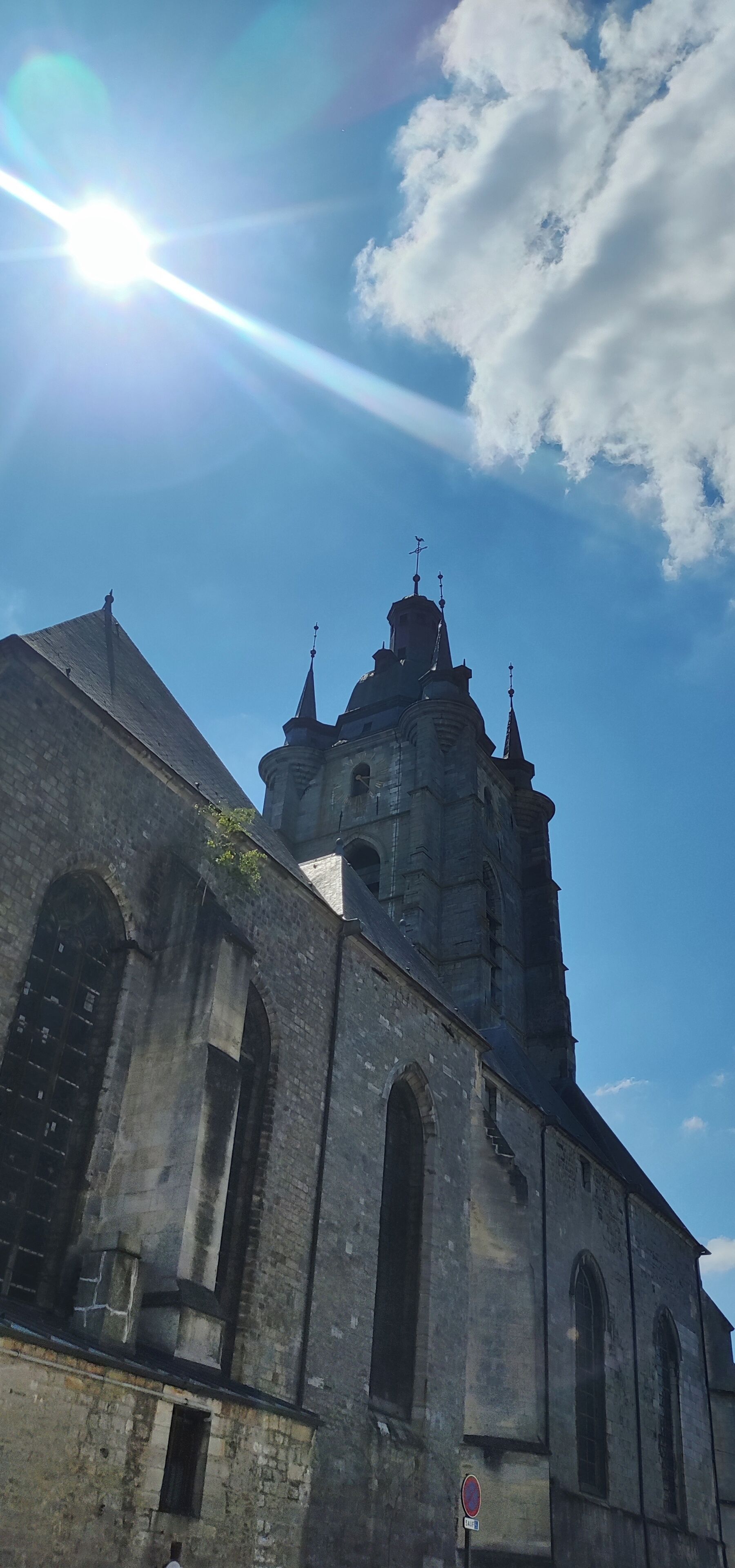 Una iglesia histórica con un campanario destacado y ventanas de arco.