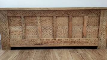 A wooden cabinet with intricate carvings and a flat top surface.
