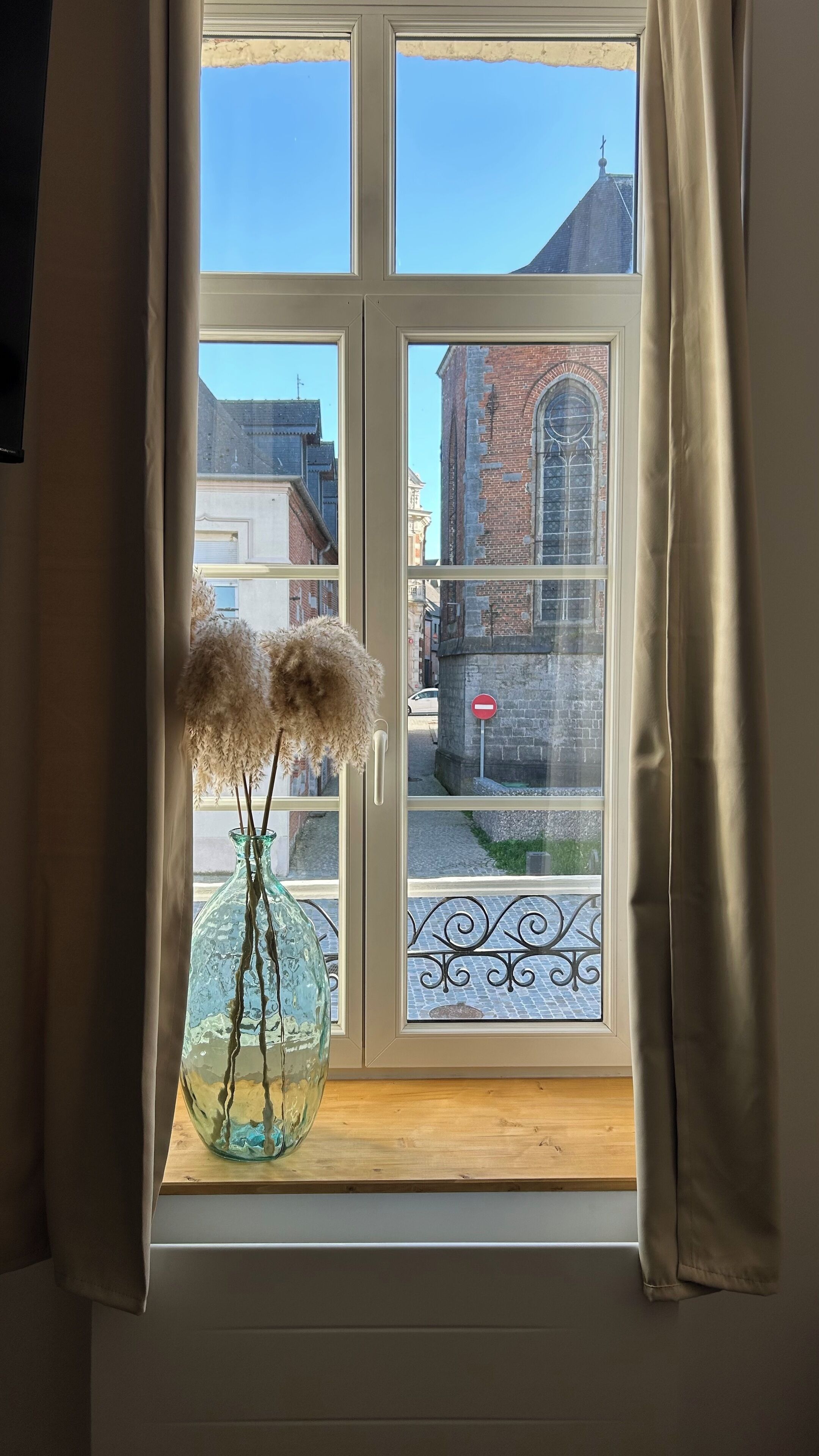 A window with a view of a brick building and a stop sign.