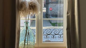 A window with a view of a brick building and a stop sign.