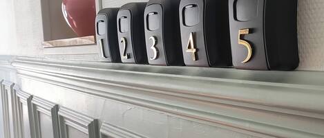A row of black number blocks on a white textured wall.